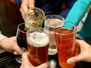 男女5人がお酒の入ったグラスを合わせて乾杯している